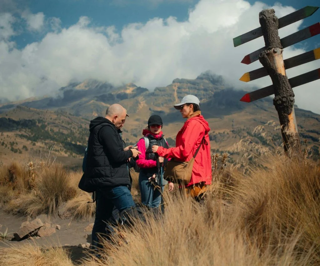 Hiker looking at map and compass at a natural trail checkpoint