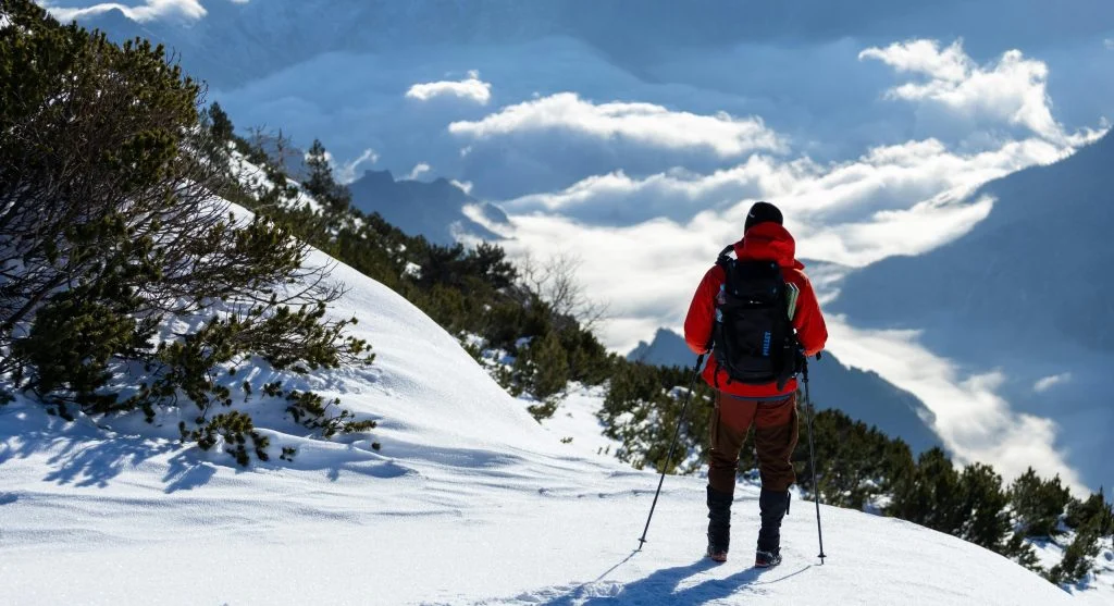 hiker adding layer in breezy conditions