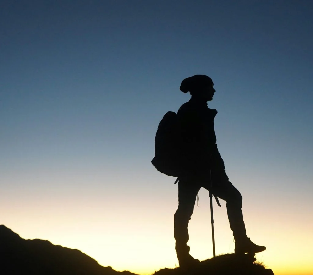 Hiker adjusting layers in the morning on a trail