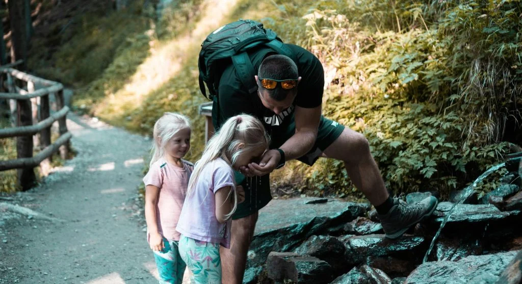 kids hiking with family on trail