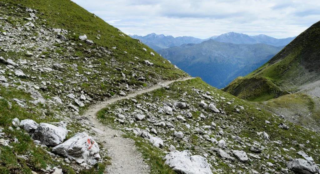 hiker using trekking poles on rugged trail