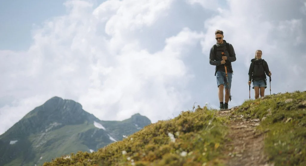 hiker using trekking poles on uneven trail